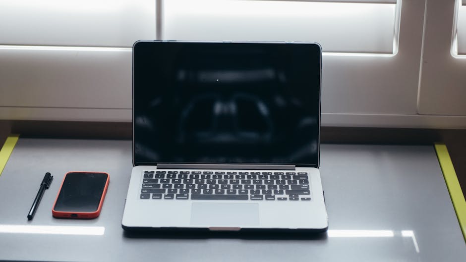 窓際の机に置かれたノートパソコンと筆記用具、オンラインフリースクール体験前の準備イメージ